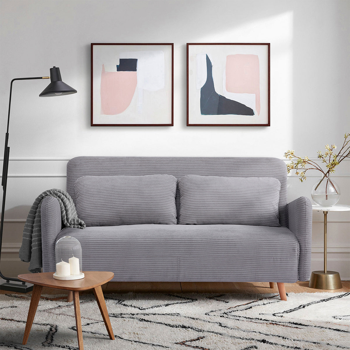 Canapé-lit BZ en velours côtelé gris clair dans un salon moderne, avec accoudoirs arrondis, pieds en bois naturel et coussins assortis. Parfait pour un couchage d’appoint et une ambiance scandinave cosy.